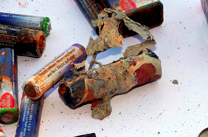 Explodierte Mignon-Batterien verschiedener Fabrikate. Teilweise stark verformt und beschädigt, Fabrikate nicht mehr erkennbar Explodierte Mignon-Batterien verschiedener Fabrikate. Teilweise stark verformt und beschädigt, Fabrikate nicht mehr erkennbar